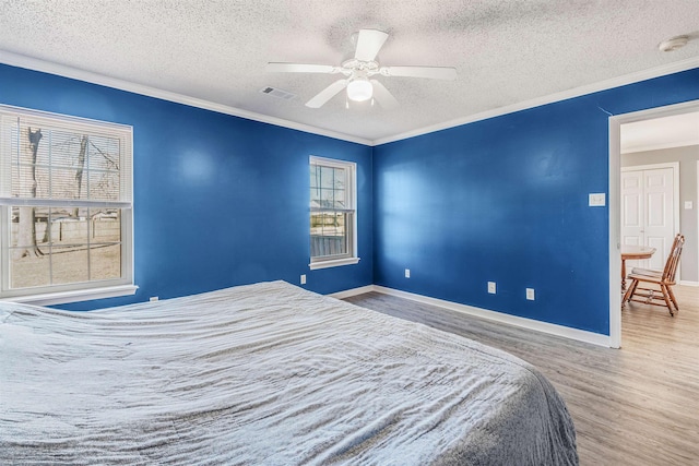 bedroom featuring multiple windows, ornamental molding, and ceiling fan