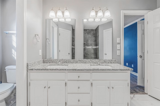 bathroom featuring a shower, ornamental molding, vanity, and toilet