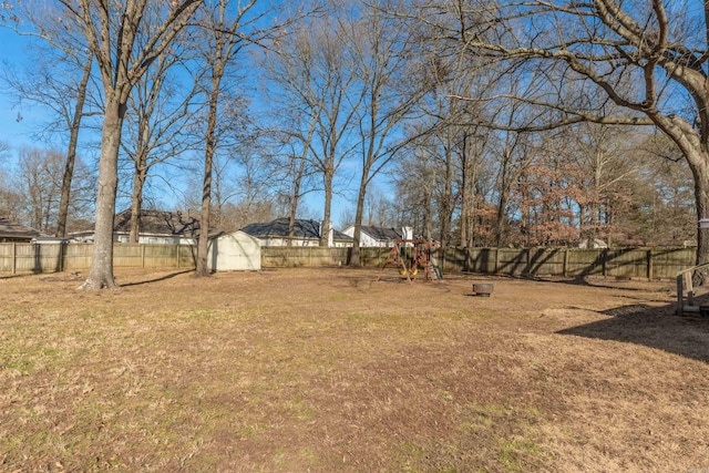 view of yard with a storage shed and a playground