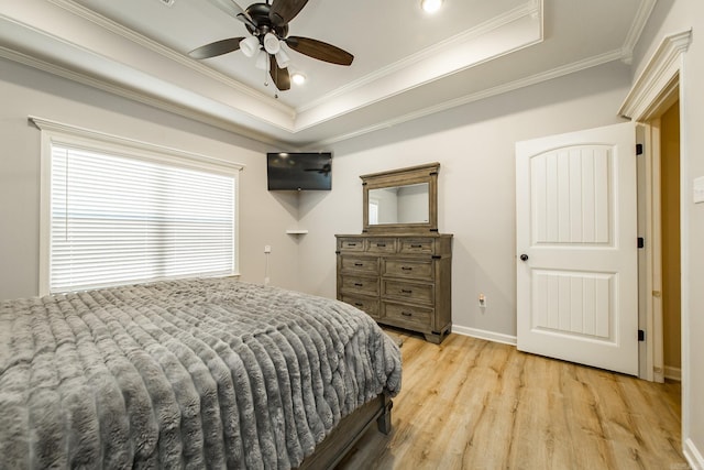 bedroom featuring crown molding, light hardwood / wood-style flooring, a raised ceiling, and ceiling fan