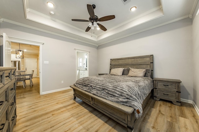 bedroom featuring crown molding, ceiling fan, a tray ceiling, and light wood-type flooring