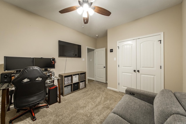 carpeted office space featuring ceiling fan