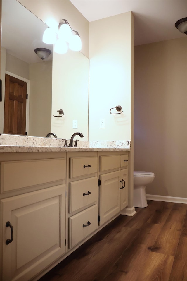 bathroom with vanity, toilet, and hardwood / wood-style floors