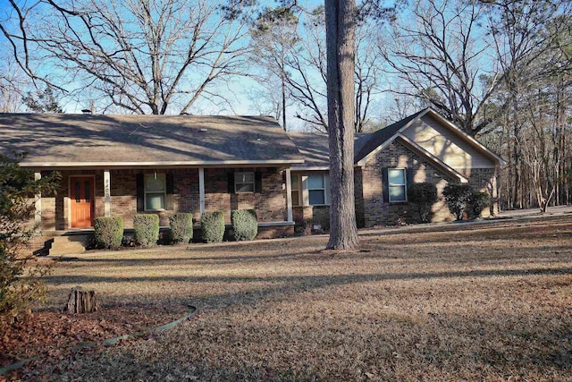 ranch-style house featuring a porch and a front yard