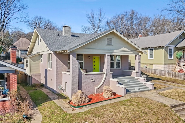 bungalow-style house with covered porch and a front lawn