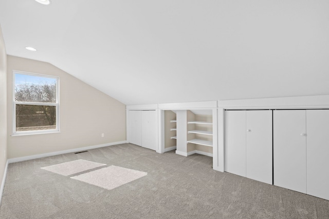 additional living space with vaulted ceiling and light colored carpet