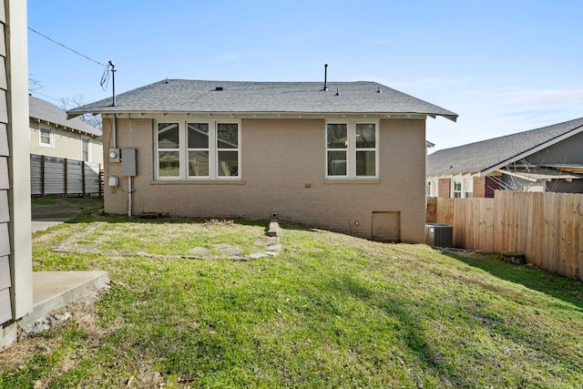 back of house featuring a yard and central AC