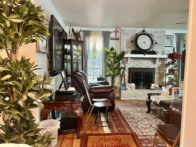 living area featuring a fireplace, hardwood / wood-style floors, and a textured ceiling