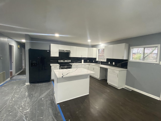 kitchen with stainless steel range with electric stovetop, white cabinetry, a center island, tasteful backsplash, and black fridge