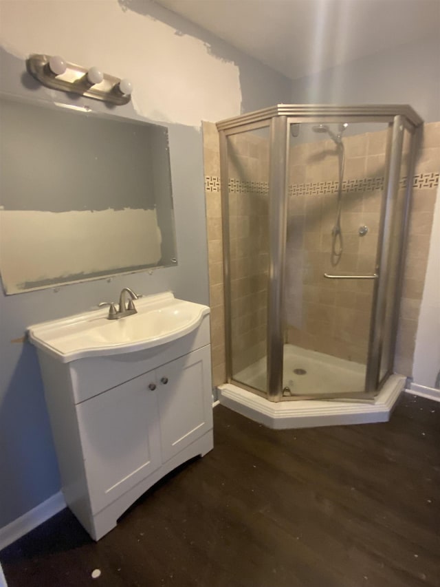 bathroom with hardwood / wood-style flooring, vanity, and a shower with door