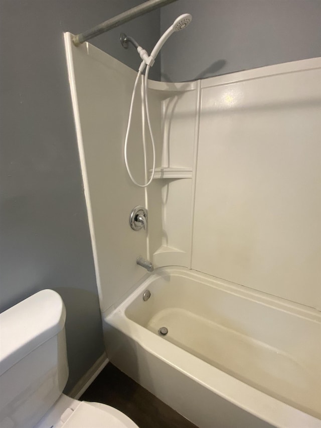 bathroom featuring shower / tub combination and toilet