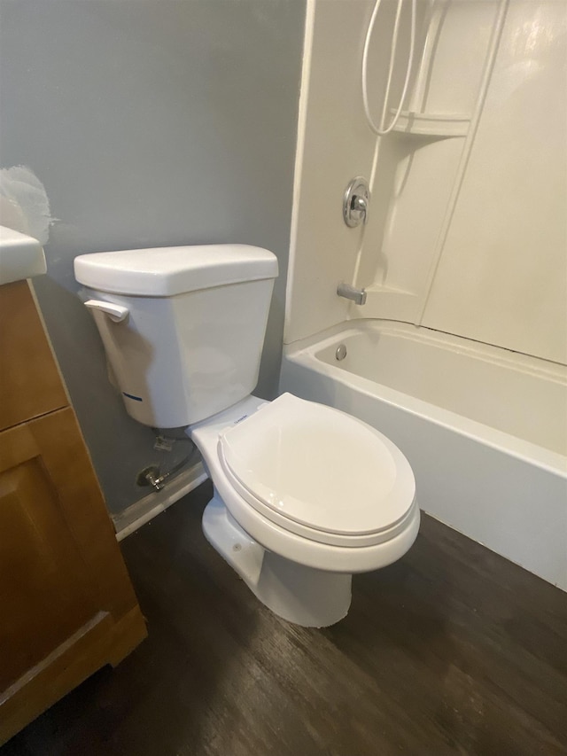 bathroom featuring hardwood / wood-style flooring,  shower combination, and toilet