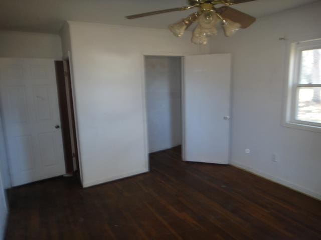 unfurnished bedroom featuring dark hardwood / wood-style flooring, ceiling fan, and a closet