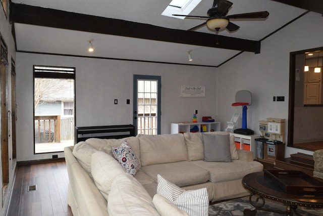 living room featuring ceiling fan, wood-type flooring, and vaulted ceiling with skylight