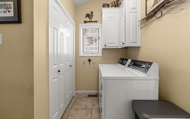 laundry area featuring cabinets, washing machine and dryer, and light tile patterned floors