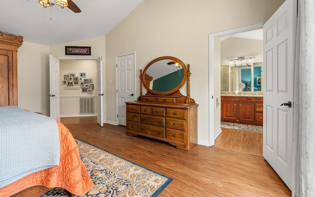 bedroom with lofted ceiling, ensuite bath, light hardwood / wood-style floors, and ceiling fan