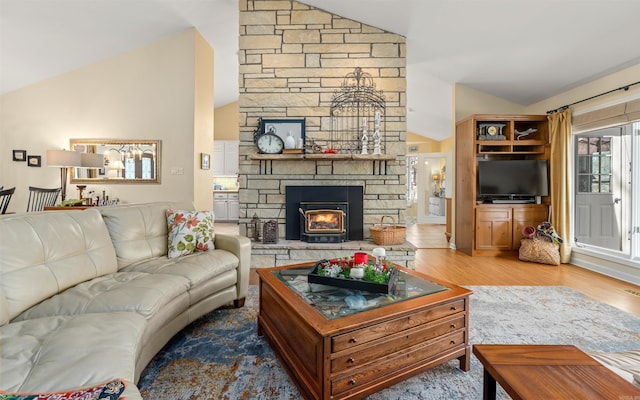 living room featuring lofted ceiling, a fireplace, and wood-type flooring