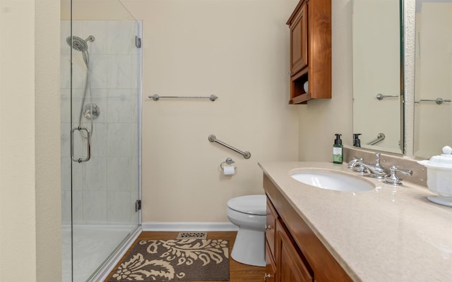 bathroom featuring a shower with door, vanity, hardwood / wood-style floors, and toilet