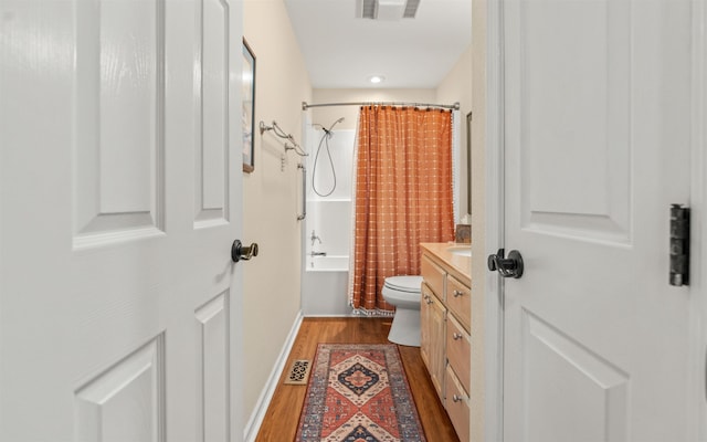 full bathroom with hardwood / wood-style flooring, vanity, shower / bath combination with curtain, and toilet