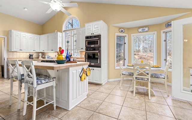 kitchen with white cabinetry, tile counters, and tasteful backsplash