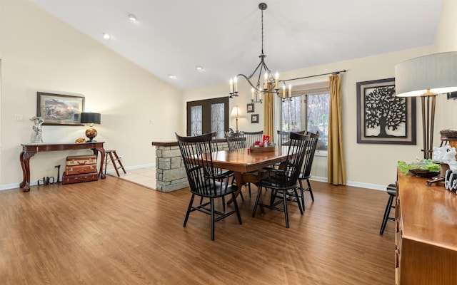 dining room with hardwood / wood-style flooring, high vaulted ceiling, a chandelier, and french doors