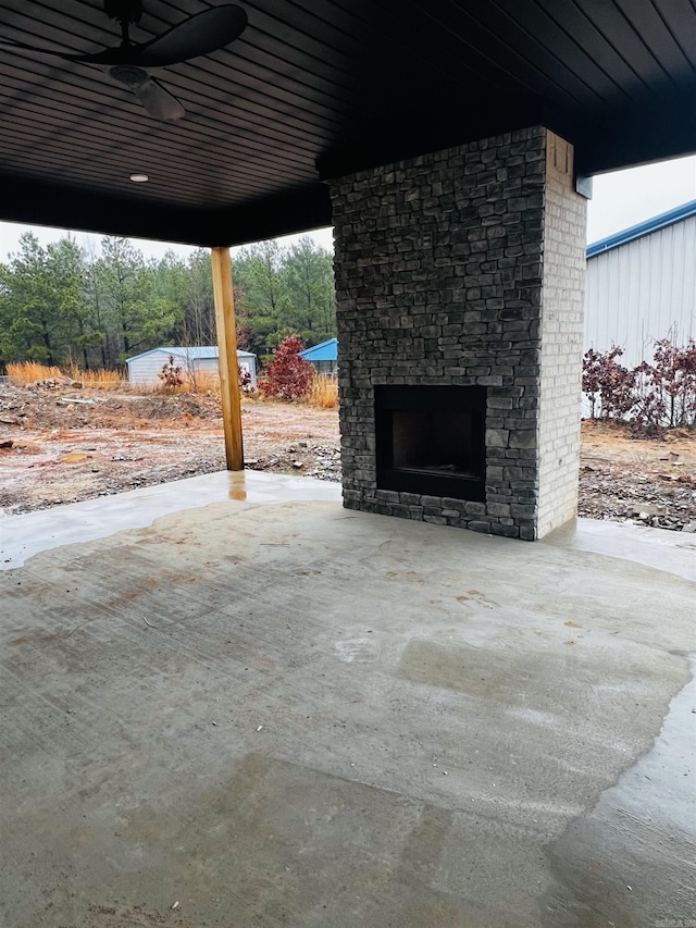 view of patio with ceiling fan and an outdoor stone fireplace