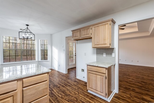 kitchen with light stone counters, tasteful backsplash, dark hardwood / wood-style floors, and light brown cabinets