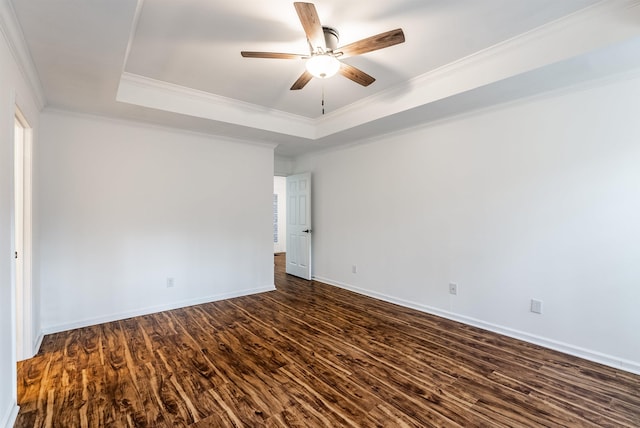 empty room with crown molding, dark hardwood / wood-style floors, ceiling fan, and a tray ceiling