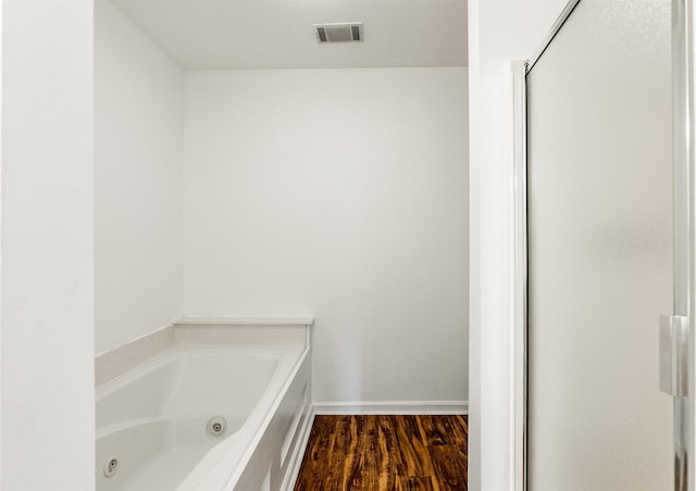 bathroom featuring a tub to relax in and hardwood / wood-style floors