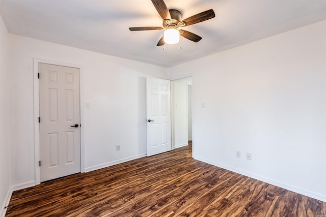 empty room with ceiling fan and dark hardwood / wood-style flooring