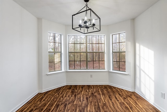 unfurnished dining area with dark hardwood / wood-style flooring and a notable chandelier