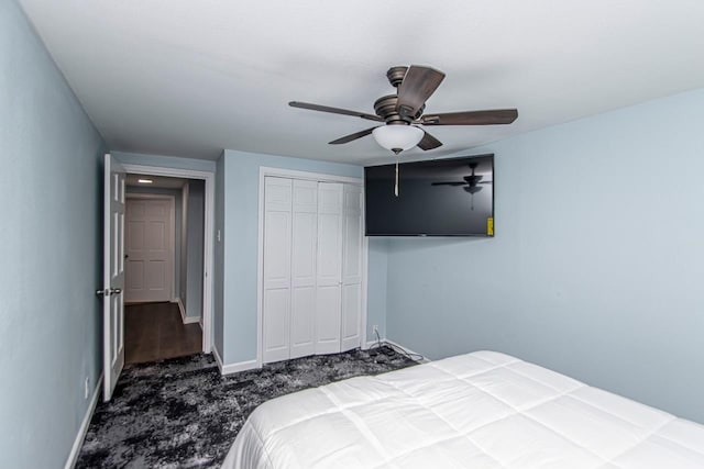 bedroom featuring ceiling fan, dark carpet, and a closet