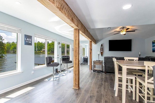 dining room featuring vaulted ceiling, a water view, dark hardwood / wood-style floors, and ceiling fan