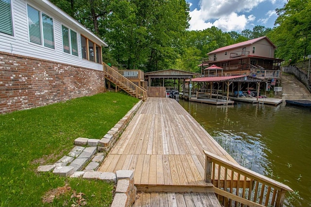 view of dock with a water view and a lawn