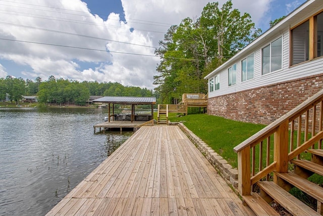 view of dock with a water view and a yard