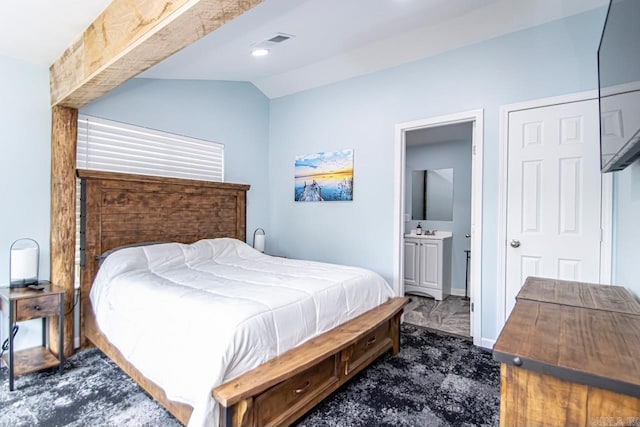 bedroom with ensuite bathroom, sink, and vaulted ceiling