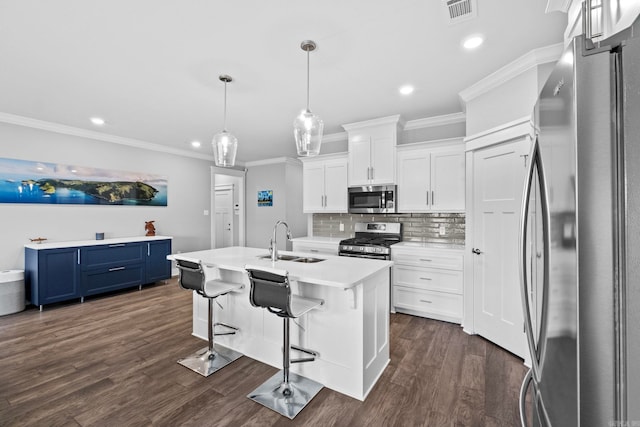 kitchen with blue cabinetry, sink, white cabinetry, appliances with stainless steel finishes, and a kitchen island with sink