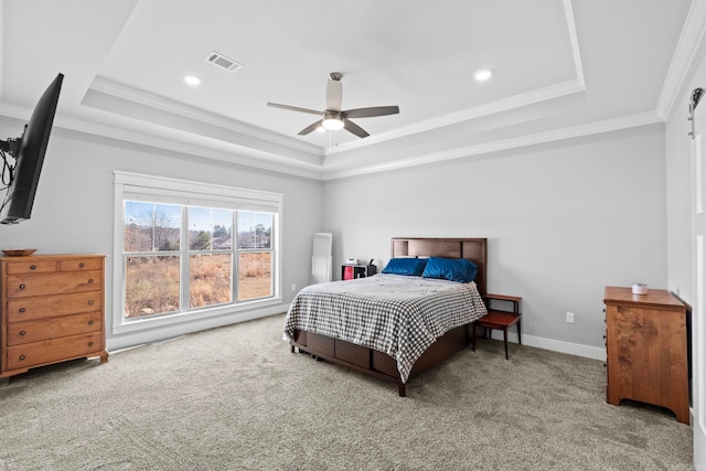 bedroom with ceiling fan, ornamental molding, a tray ceiling, and carpet floors