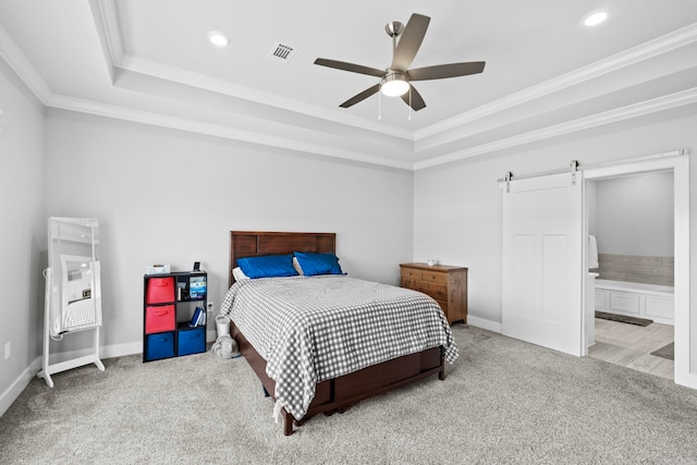 carpeted bedroom featuring connected bathroom, ornamental molding, a tray ceiling, ceiling fan, and a barn door