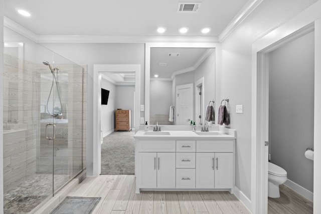 bathroom featuring vanity, ornamental molding, toilet, and walk in shower