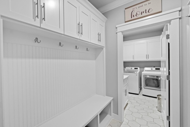 mudroom with washing machine and clothes dryer, ornamental molding, and light tile patterned floors