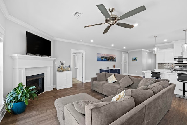 living room featuring ceiling fan, ornamental molding, and dark hardwood / wood-style flooring