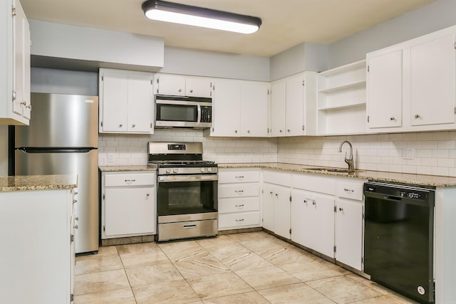 kitchen with sink, white cabinetry, tasteful backsplash, stainless steel appliances, and light stone countertops