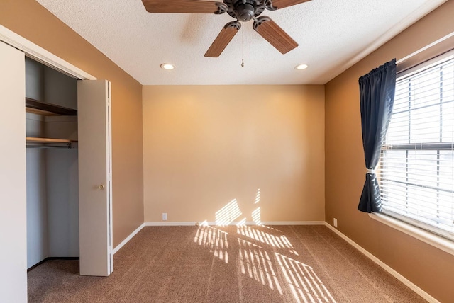 unfurnished bedroom featuring ceiling fan, a closet, carpet, and a textured ceiling