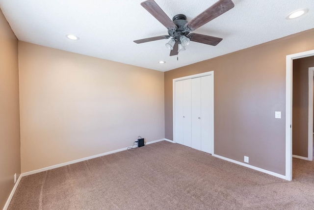 unfurnished bedroom featuring carpet floors, ceiling fan, and a closet