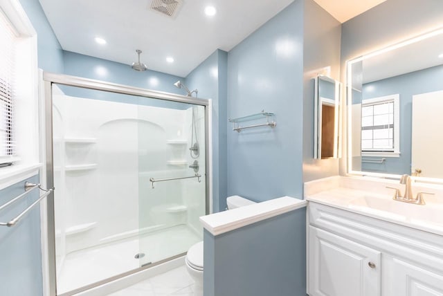 bathroom featuring vanity, an enclosed shower, and toilet