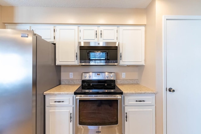 kitchen featuring white cabinetry, appliances with stainless steel finishes, and a textured ceiling