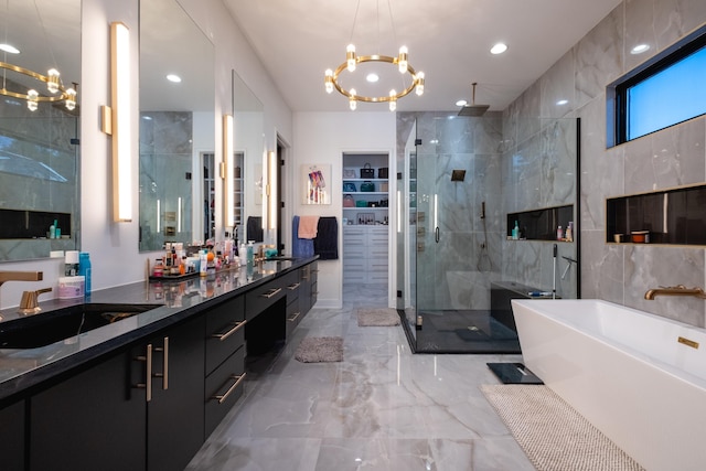 bathroom with vanity, plus walk in shower, a chandelier, and tile walls