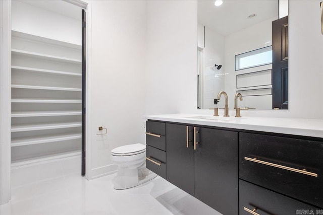 bathroom featuring tile patterned flooring, vanity, toilet, and walk in shower