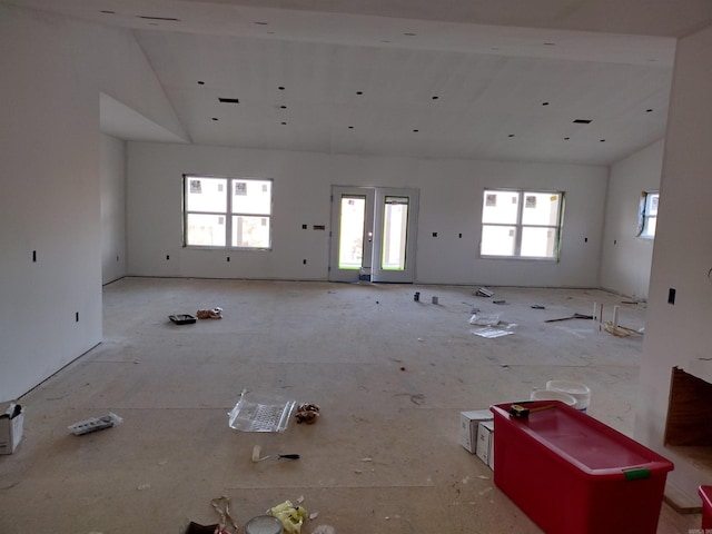 unfurnished living room with high vaulted ceiling